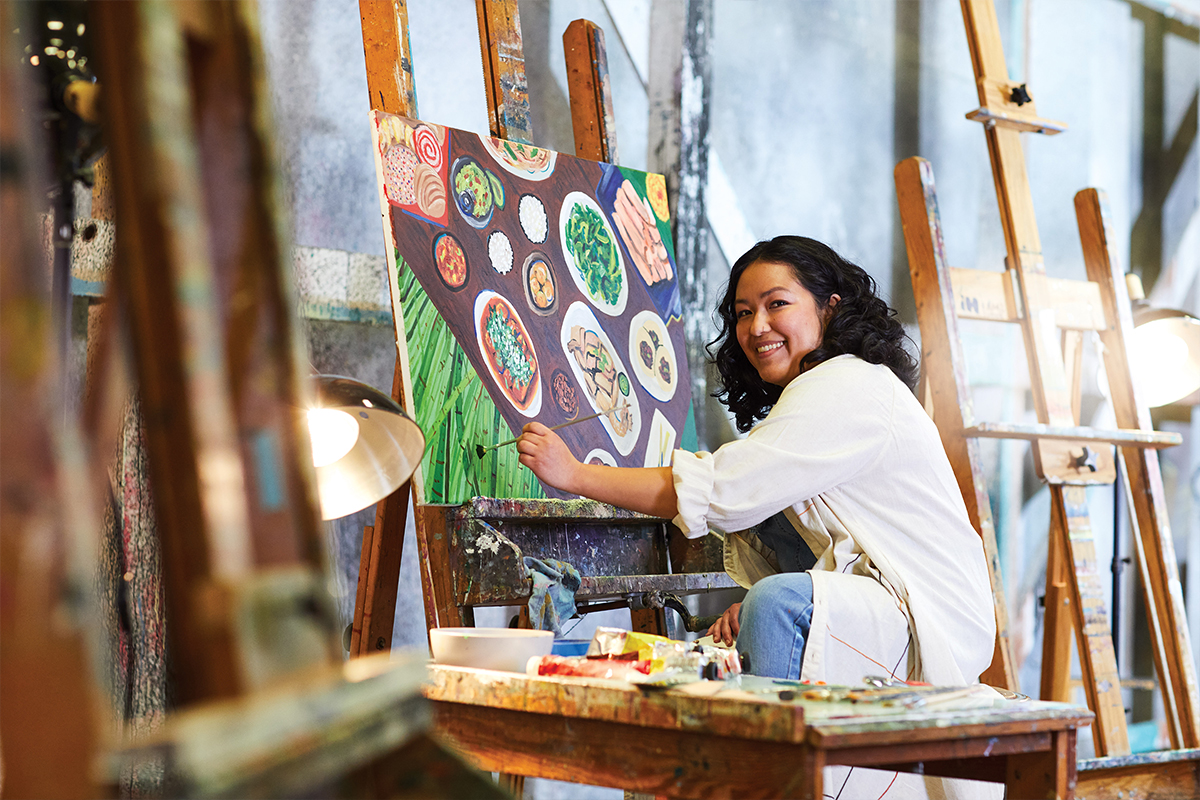 San Francisco State University student painting a cultural spread of food 